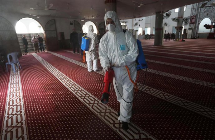 Trabajadores palestinos desinfectando una mezquita en Gaza