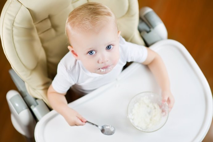 Niño pequeño comiendo arroz.