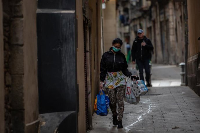 Una dona protegida amb mascarilla durant el segon dia laborable de l'estat d'alarma pel coronavirus, a Barcelona (Espanya), a 17 de mar de 2020 (arxiu)
