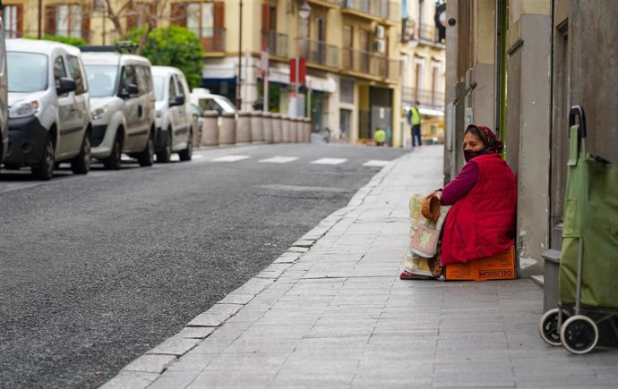 Una indigente el la puerta de un supermercado durante el tercer día laborable desde que se decretó el estado de alarma a consecuencia del coronavirus, en Sevilla (España), a 18 de marzo de 2020 (archivo)