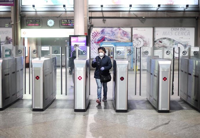 Una mujer pasa los tornos de la Renfe de Atocha donde los militares de la División Acorazada del Ejército controlan la estación durante el cuarto día laborable del estado de alarma por la crisis del coronavirus en España, en Madrid (España). (Archivo)