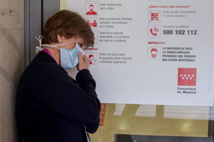 Una enfermera descansa en una de las puertas pertenecientes al Hospital Gregorio Marañón de Madrid en el primer día laborable del estado de alarma por el coronavirus en Madrid, en Madrid (España), a 16 de marzo de 2020.