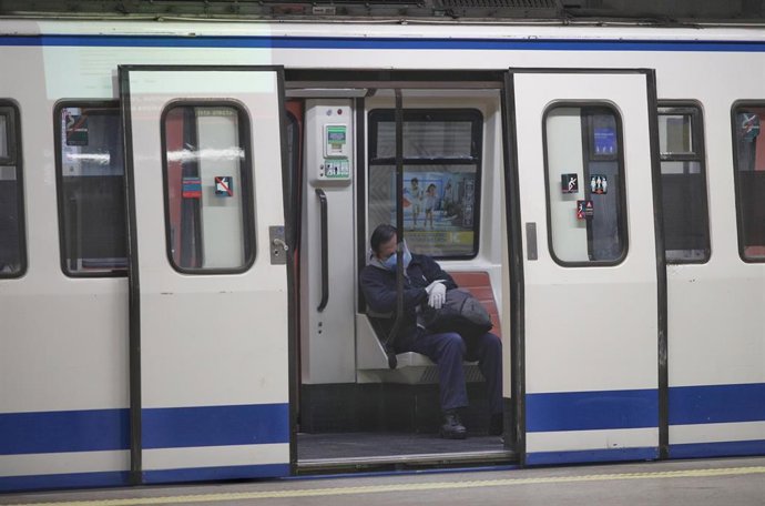 Un hombre protegido con mascarilla y sentado dentro del metro en Atocha donde los militares de la División Acorazada del Ejército controlan la estación durante el cuarto día laborable del estado de alarma por la crisis del coronavirus en España, en Madr