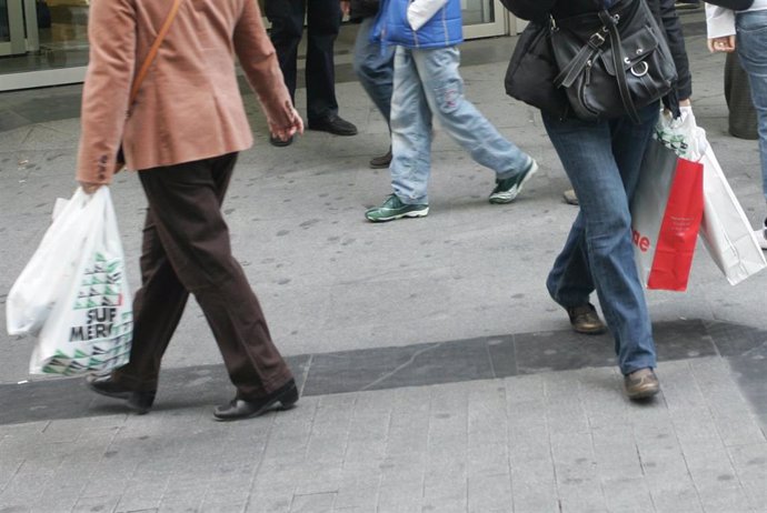 Gente paseando con bolsas de plástico en la mano
