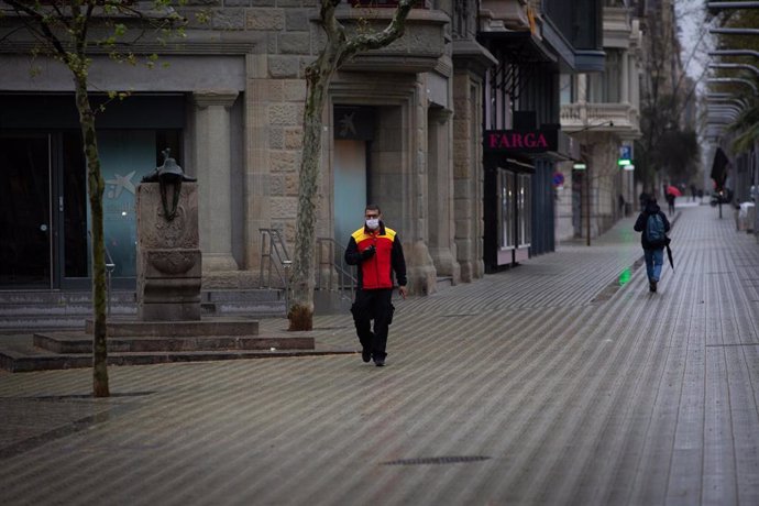 Un home protegit amb una mascarilla, durant el segon dia laborable de l'estat d'alarma pel coronavirus, a Barcelona (Espanya), a 17 de mar de 2020.