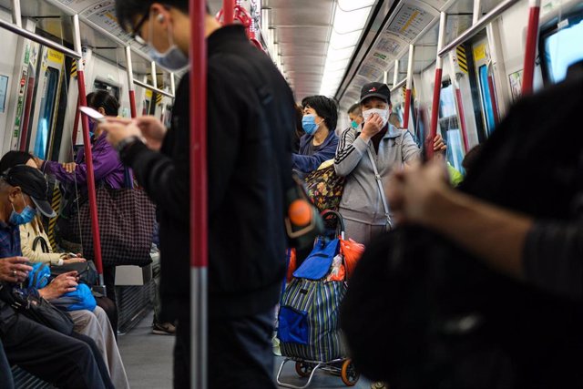 Usuarios del metro de Hong Kong se protegen de un posible contagio de coronavirus utilizando mascarillas.