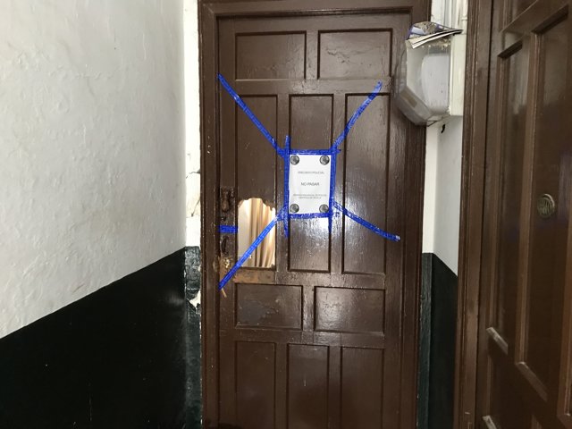 Puerta de la vivienda donde un hombre ya detenido ha agredido a su pareja en Sevilla