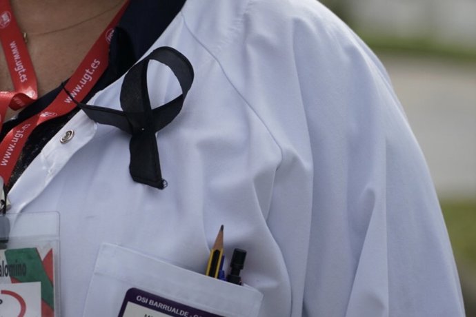 Una sanitaria del Osakidetza (servicio vasco de salud)  del Hospital de Galdakao  con un lazo negro de luto en recuerdo a la enfermera de 52 años fallecida por Covid-19 