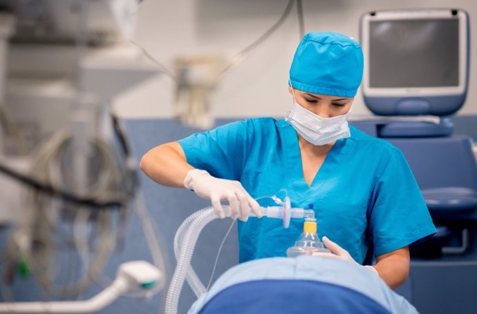 Nurse putting oxygen mask to patient during surgery