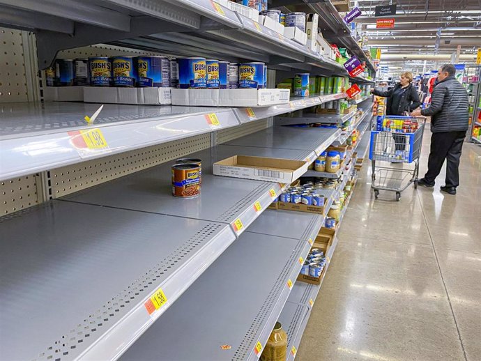 15 March 2020, US, Ankeny: A couple shops in the canned goods aisle at the Walmart store, amid a wave of panic buying as a result of the coronavirus scare. Photo: Jack Kurtz/ZUMA Wire/dpa