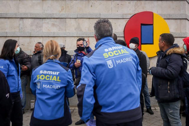 Trabajadores del Samur Social junto a algunas de las personas sin hogar que ocuparán el pabellón 14 de Feria de Madrid, que ha sido acondicionado para sintechos mientras dure la crisis del coronavirus, en Madrid (España), a 20 de marzo de 2020.