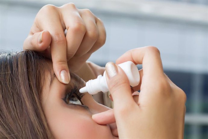 Woman using eye drop, eye lubricant to treat dry eye or allergy