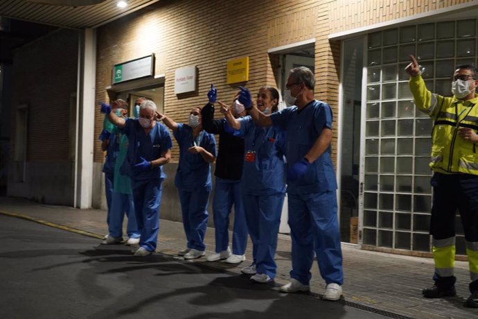 Personal sanitario del hospital Virgen del Rocio de Sevilla aplauden en la puerta de Urgencia del centro