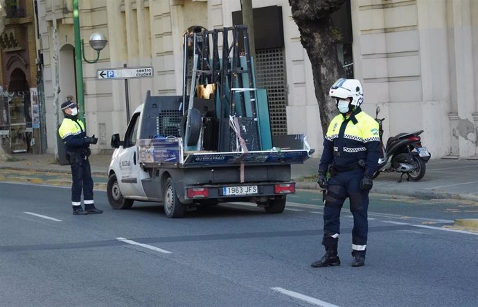 Policías municipales de Sevilla controlan la Avenida de Luis Montoto de la ciudad para cumplir el estado de alarma 
