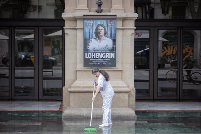 Una mujer limpia en la puerta del Gran Teatre del Liceu Barcelona durante el tercer día laborable del estado de alarma por coronavirus, en Barcelona/Catalunya (España) a 18 de marzo de 2020.