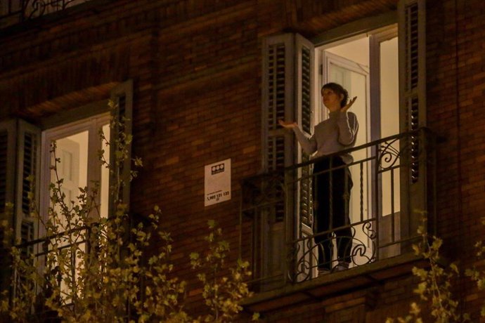 Una mujer aplaude desde su balcón por la labor que están realizando los sanitarios ante la crisis de contagios por el coronavirus, en Madrid (España), a 17 de marzo de 2020.