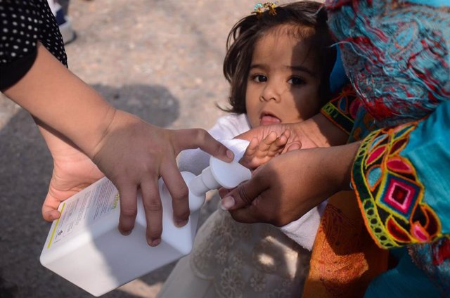 Una madre y su hija se limpian las manos con un gel hidroalcohólico en Peshawar
