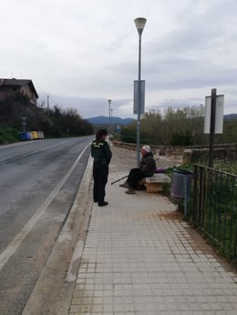 Agente de la Guardia Civil atiende a un peregrino del Camino de Santiago durante el estado de alarma