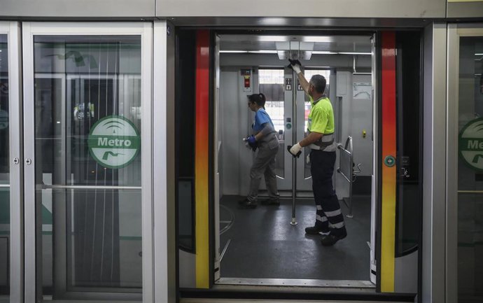 Dos trabajadores limpian los pasamanos y barandillas del metro para combatir la propagación de la epidemia del coronavirus Covid-19. En Sevilla, (Andalucía, España), a 12 de marzo de 2020.