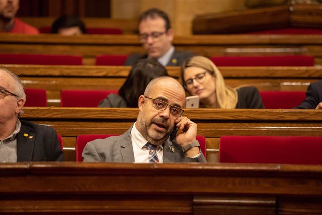 El conseller de Interior de la Generalitat, Miquel Buch, hablar por el móvil en su escaño durante un pleno extraordinario convocado tras la decisión de la Junta Electoral Central (JEC) de inhabilitar al president de la Generalitat, en Barcelona (Cataluña,