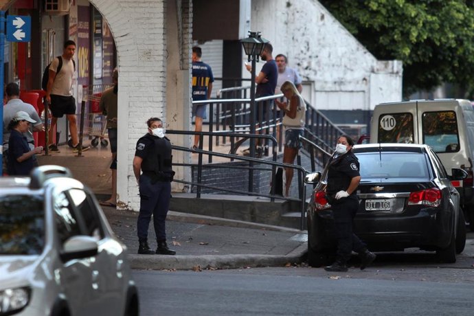 Trabajadora de seguridad con mascarilla frente a un supermercado en Buenos Aires, Argentina