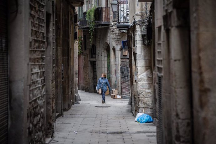 Una mujer anda por una calle de Barcelona durante el segundo día laborable del estado de alarma por el coronavirus, en Barcelona (España), a 17 de marzo de 2020.
