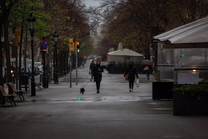 Una mujer pasea a su perro durante el segundo día laborable del estado de alarma por el coronavirus, en Barcelona (España), a 17 de marzo de 2020.