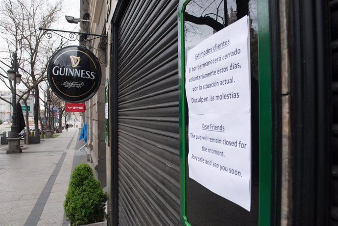 Entrada de un bar con un cartel en la entrada en la que se avisa de su cierre temporal, durante el estado de alarma decretado por el coronavirus, en Madrid (España), a 16 de marzo de 2020.
