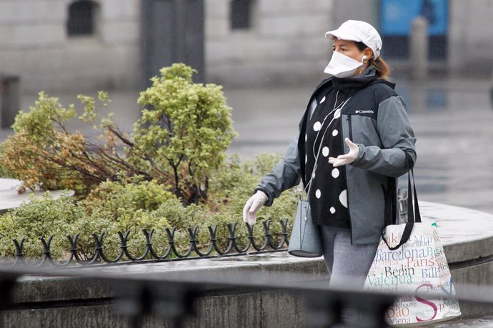 Una mujer protegida con mascarilla y guantes sanitarios realiza compras durante el sexto da del estado de alarma por coronavirus.