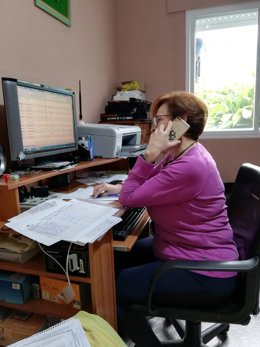 Una persona habla con mayores a través del teléfono puesto a disposición por la Diputación de Málaga