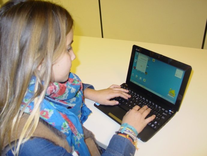 Una escolar, con un ordenador portátil.