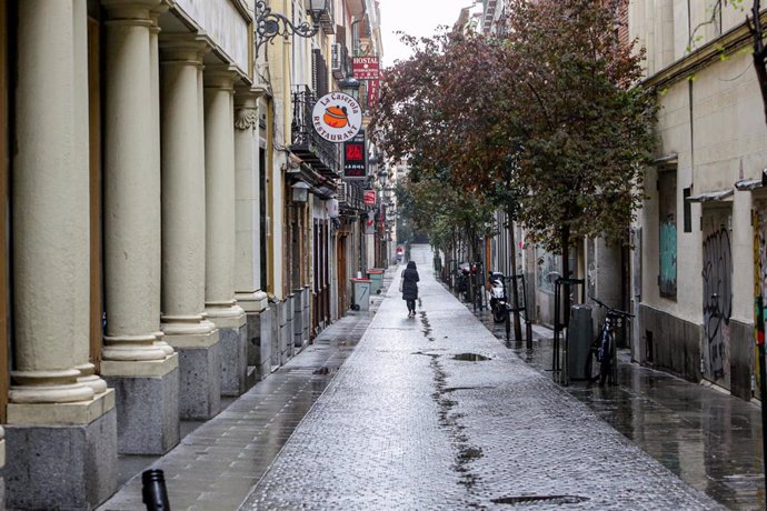 Una persona camina por una calle de Madrid vacía y con negocios cerrados durante el estado de alarma, en Madrid (España) a 21 de marzo de 2020.