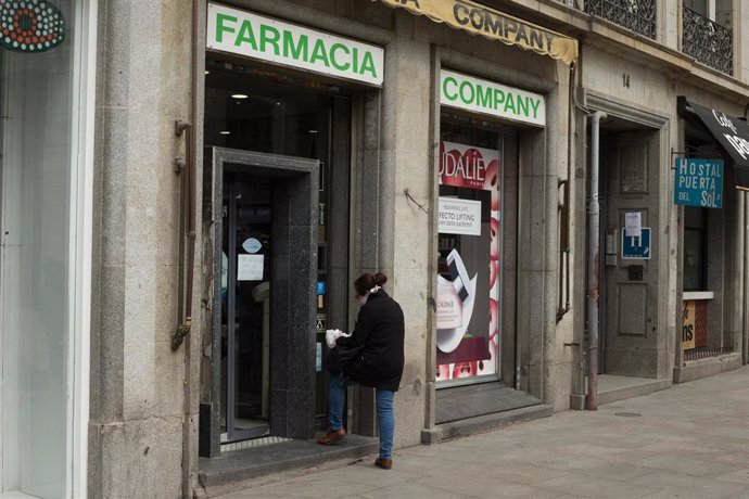 Una mujer entra en una farmacia del centro de la capital que amanece totalmente vacía durante el sexto día de confinamiento por coronavirus en el país, en Madrid, (España), a 20 de marzo de 2020.