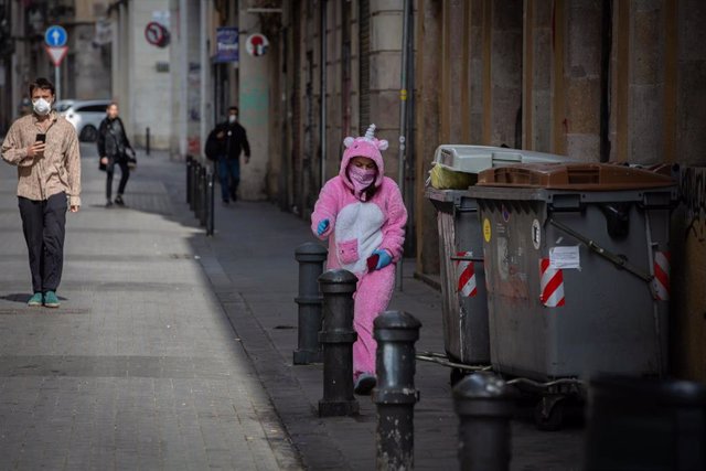 Una mujer con un traje de unicornio y protegida con mascarilla y guantes durante el primer día laborable de la segunda semana desde que se decretó el estado de alarma en España a consecuencia del coronavirus.