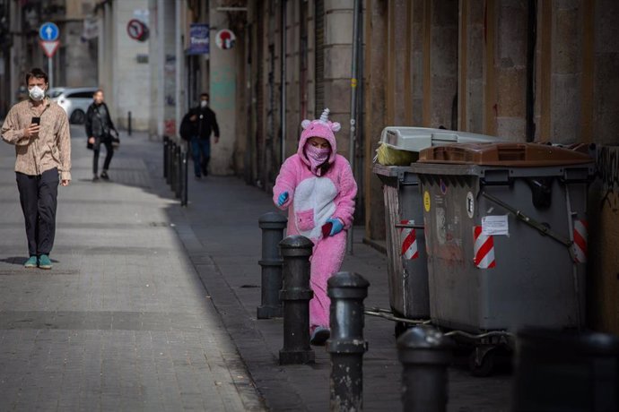 Una mujer con un traje de unicornio y protegida con mascarilla y guantes durante el primer día laborable de la segunda semana desde que se decretó el estado de alarma en España a consecuencia del coronavirus.