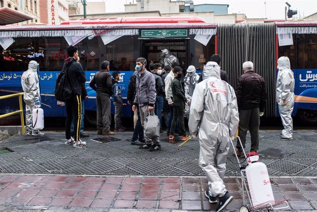 Trabajadores voluntarios desinfectando un autobús en Teherán