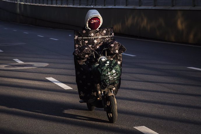 Una mujer en moto por las calles de la ciudad de Wuhan, epicentro de la epidemia del nuevo coronavirus