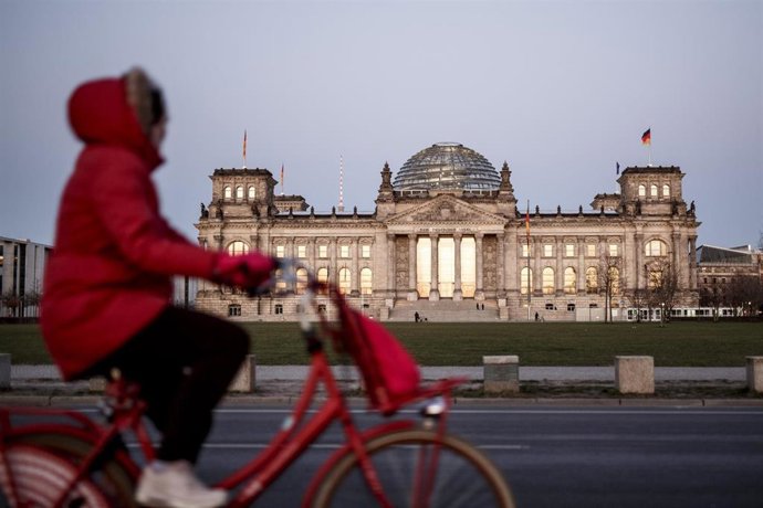 Una mujer paseando con su bici frente al Reichstag
