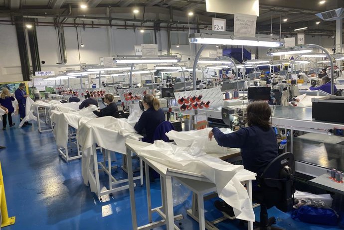 Empleados de Grupo Antolin produciendo batas.