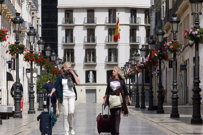 Dos personas con maletas recorren la calle Larios durante el segundo día laborable del estado de alarma a causa de la pandemia del nuevo coronavirus (COVID-19). En Málaga, (Andalucía, España), a 17 de marzo de 2020.