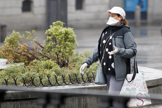 Una mujer protegida con mascarilla y guantes sanitarios realiza compras durante el sexto da del estado de alarma por coronavirus, en Madrid (Espaa) a 21 de marzo de 2020.