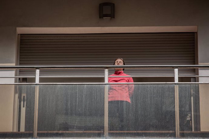 Una dona pren el sol en la seva terrassa durant el primer dia laborable de la segona setmana des que es va decretar l'estat d'alarma al país a conseqüncia del coronavirus, a Barcelona/Catalunya (Espanya) a 23 de mar de 2020.