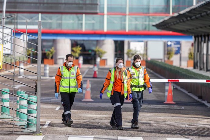 Tres miembros del personal de Emergencias Madrid con mascarillas a la entrada de Ifema