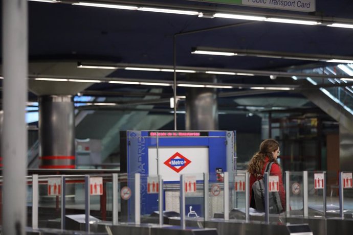 Una mujer camina dentro de la estación de Nuevos Ministerios que a partir de hoy junto al resto de estaciones de la capital, martes 24 de marzo, cerrará sus puertas a las 24 horas.