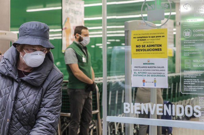 Una mujer con mascarilla a las puertas de un Mercadona.