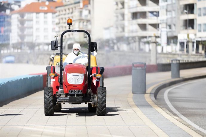 Un vecino de Sanxenxo subido en un tractor agrícola fumiga la principal localidad turística gallega.