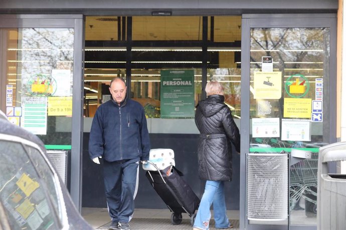 Dos clientes entran a hacer la compra a un supermercado Mercadona en plena crisis sanitaria por coronavirus donde los españoles llevan confinados en sus hogares más de una semana.