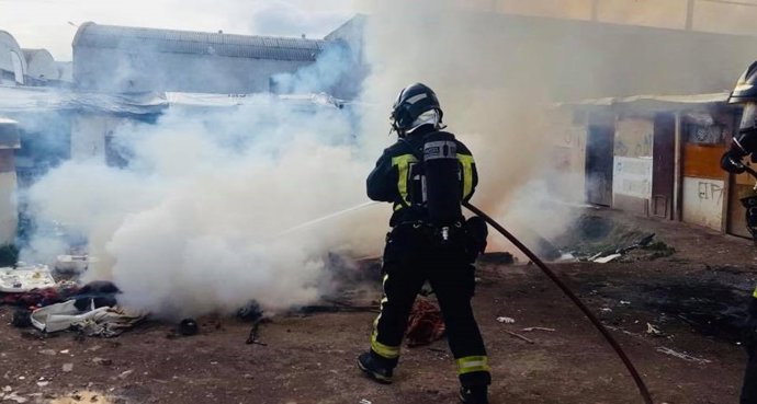 Bomberos sofocando las llamas en el asentamiento de chabolas