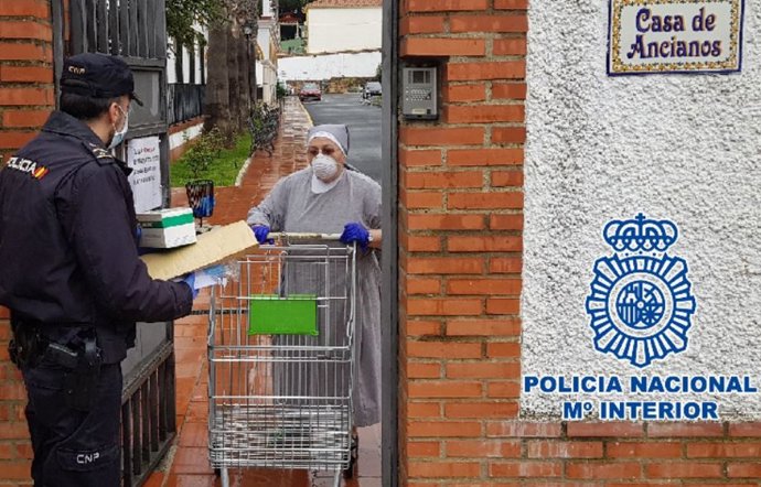 Un agente de Policía Nacional reparte mascarillas en un centro de ancianos en Málaga y Ronda frente al COVID-19