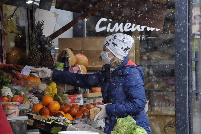 Una mujer con mascarilla en un mercado de Kiev